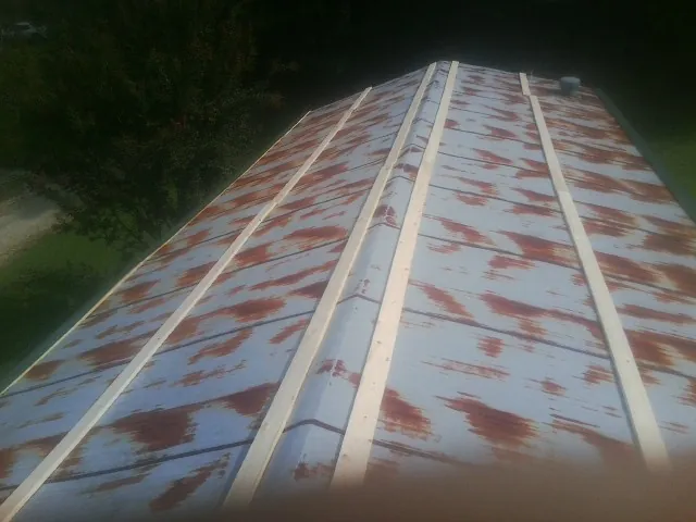 Rusted metal roof panels with new wood purlins before replacement — Storm Damage Roof Repair in Churubusco by Roofing Brothers